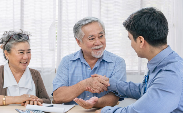 Happy clients shaking their real estate attorneys hand after closing